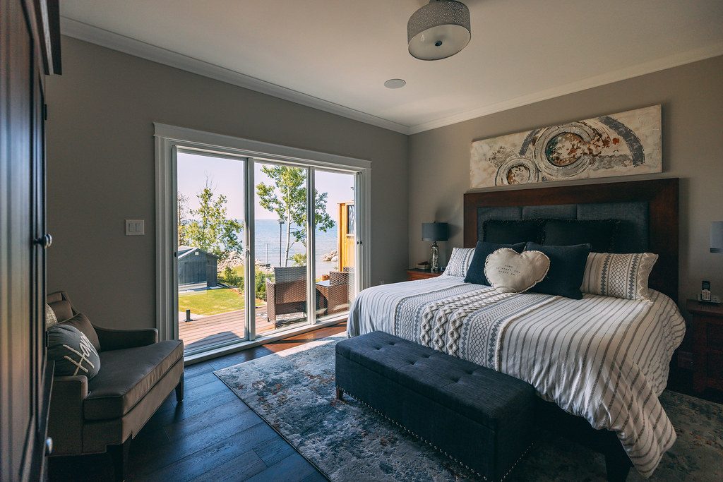 Bright airy bedroom with large windows and sliding doors letting in soft morning light